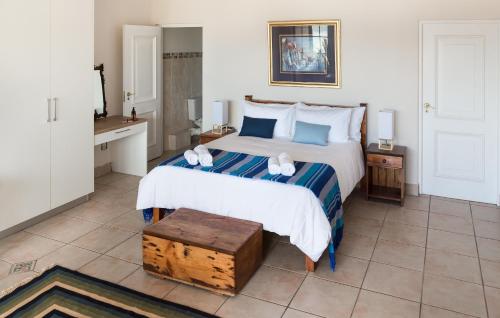 a bedroom with a large white bed with a wooden box on it at Moncrieff Manor in Knysna