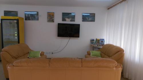 uma sala de estar com um sofá e uma televisão de ecrã plano em Park Golf Hostel Ipelandia em Foz do Iguaçu