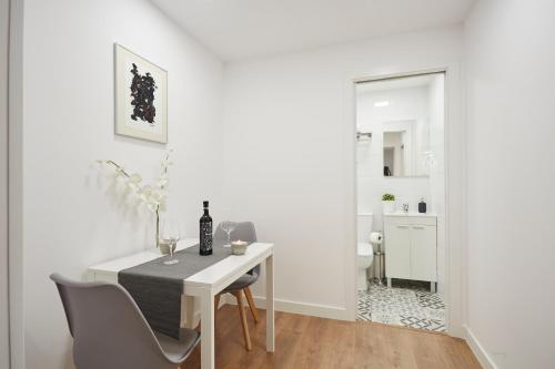 un comedor blanco con mesa y sillas en LEEWAYS APARTMENT in SAN LORENZO en Madrid