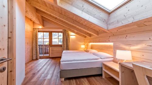 - une chambre dans une cabane en rondins avec un lit et un bureau dans l'établissement Residence Cesa Rives, à Selva di Val Gardena