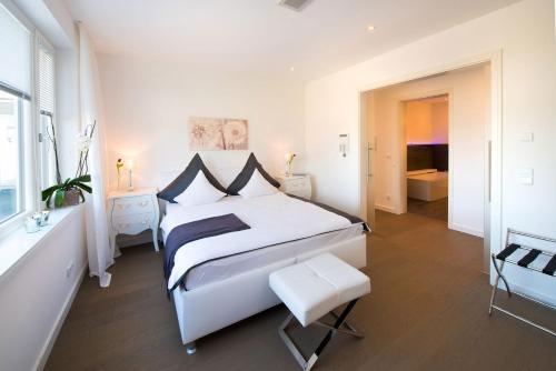 a white bedroom with a large bed and a window at View & Garden Villa Schauenstein in Schauenstein