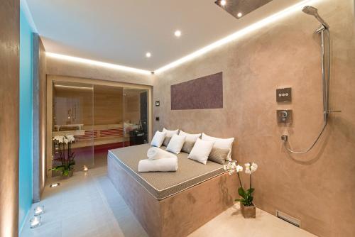 a bathroom with a shower and a bed with towels at View & Garden Villa Schauenstein in Schauenstein