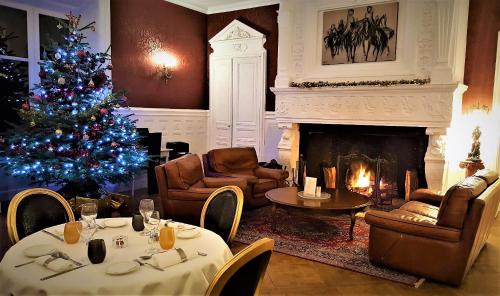 a living room with a christmas tree and a fireplace at Château de Bellefontaine - Teritoria in Bayeux