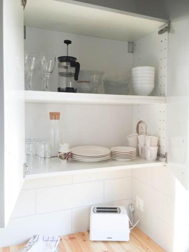 a kitchen with white cabinets and plates and a toaster at South Central Country-Apartment in Brautarholt