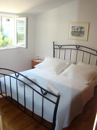 a bedroom with a large bed with white sheets at Apartments Ada in Tučepi