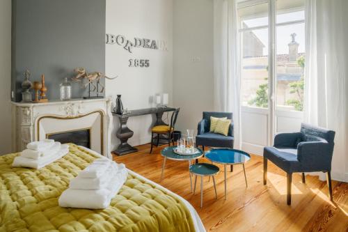 sypialnia z łóżkiem, krzesłami i kominkiem w obiekcie Le Clos Labottière - B&B w mieście Bordeaux