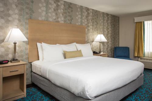 a bedroom with a large bed and a blue chair at Milford Inn in Milford