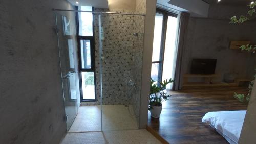a glass shower in a room with a bedroom at 日月潭山慕藝旅 Sun Moon Inn in Yuchi