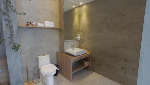 a bathroom with a sink and a toilet and a mirror at 日月潭山慕藝旅 Sun Moon Inn in Yuchi