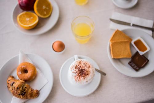 a table with plates of breakfast foods and drinks at Hotel Villino Gallodoro in Taormina