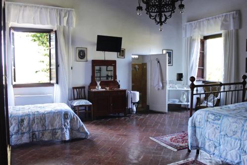 a bedroom with a bed, chair and a window at Villa Aurora di Ferracciano in Borgo San Lorenzo