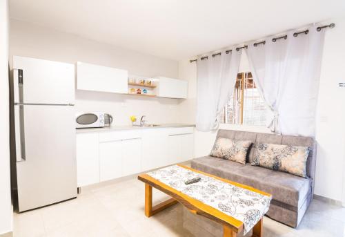 a kitchen with a couch and a table in a room at Asher's Apartments in Eilat