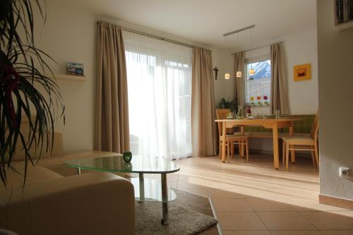 ein Wohnzimmer mit einem Sofa und einem Tisch in der Unterkunft Appartement Wildkogel in Neukirchen am Großvenediger
