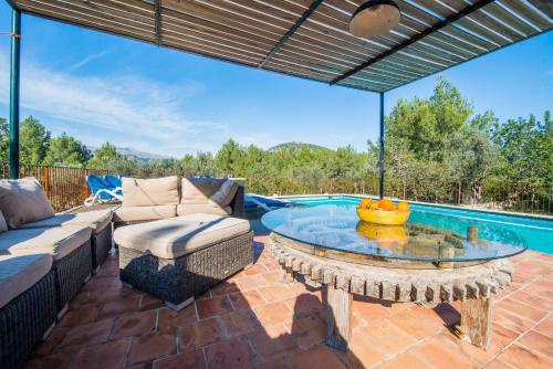 a patio with a couch and a table and a pool at Can Guillo in Pollença