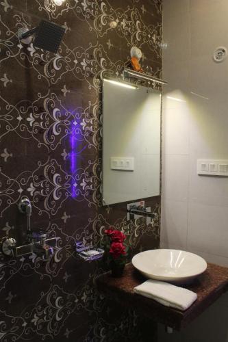 a bathroom with a sink and a mirror at Regal Hotel and restaurant in Mathura