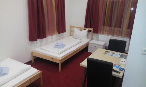 een kleine kamer met een bed en een tafel bij Gasthof zum Nibelungenbauer in Pöchlarn