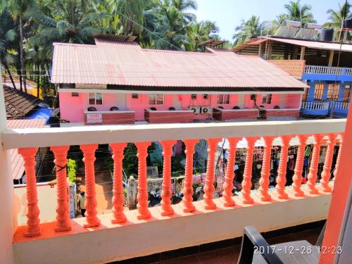 a view from a balcony of a pink house at Sobitai in Palolem