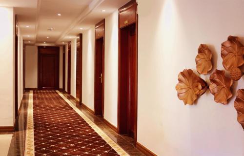 a corridor of a hotel with a hallway with art on the walls at Chang Palace Vientiane in Vientiane