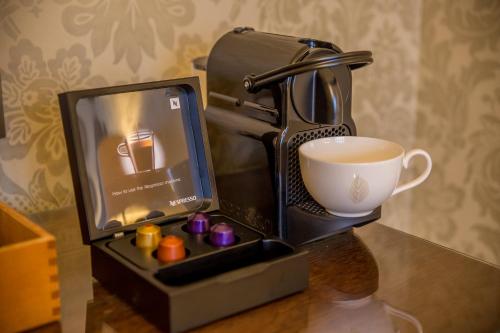 a coffee maker and a cup of coffee on a table at Bovey Castle in Moretonhampstead