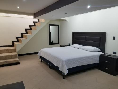 1 dormitorio con 1 cama grande y una escalera en Casa Margarita Hotel And Paradise, en Las Lisas