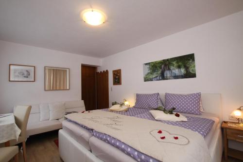 a bedroom with a large bed and a desk at Pension Garni Gerhard in Oetz