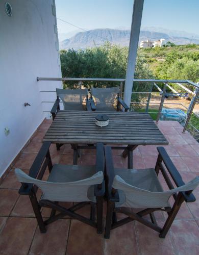 a wooden table and chairs on a balcony at Ktima Nikolaos in Arónion