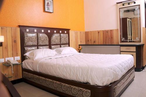 a bedroom with a large bed and a mirror at Hotel Sree Baalaaji Bhavan in Dindigul
