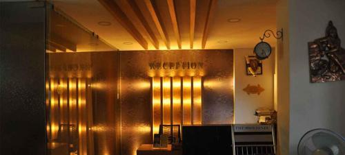 a large metal wall in a room with a clock at Hotel Sree Baalaaji Bhavan in Dindigul