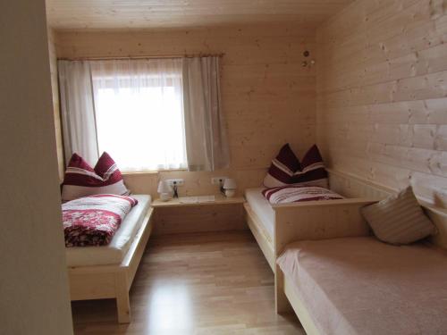 a small room with two beds and a window at Ebner Casa in Heiligenblut