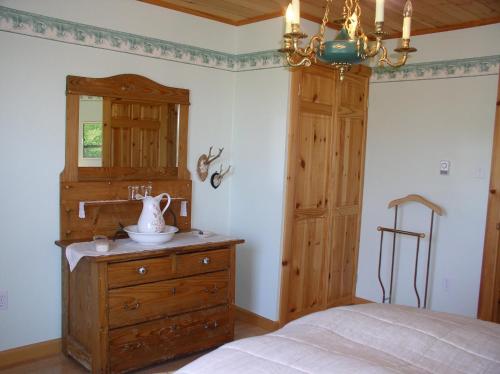 a bedroom with a bed and a dresser and a chandelier at Haus Treuburg in Port Hood