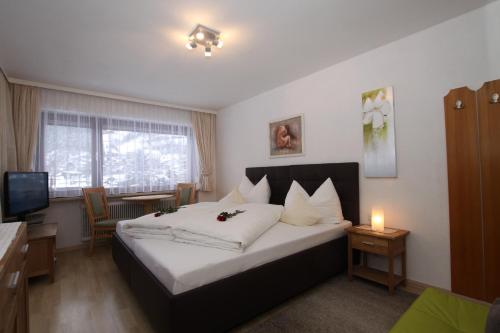 a hotel room with a bed and a television at Pension Garni Gerhard in Oetz