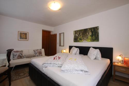 a bedroom with a large bed with pillows on it at Pension Garni Gerhard in Oetz