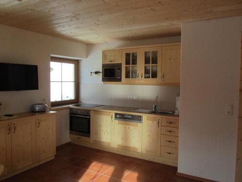 a kitchen with wooden cabinets and a sink and a window at Ebner Casa in Heiligenblut