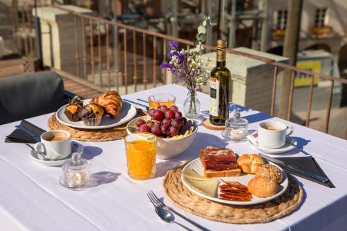 a table with plates of food and a bottle of wine at Aire Hotel & Ancient Baths in Almería