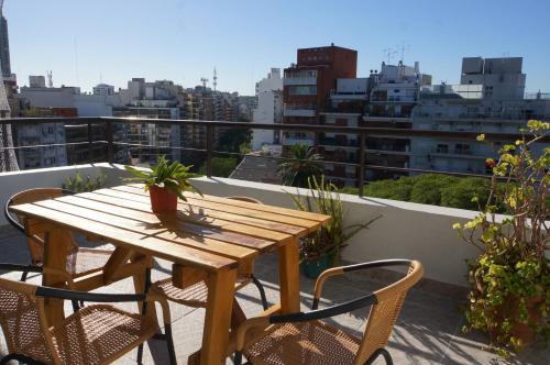 y balcón con mesa y sillas de madera. en Ático Palermo en Buenos Aires