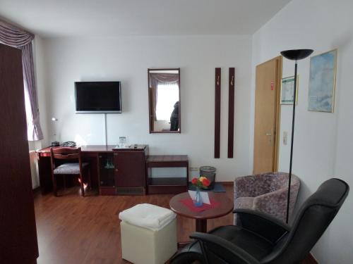 a living room with a chair and a desk at Hotel Wildunger Hof mit Gemeinschaftsküche in Bad Wildungen