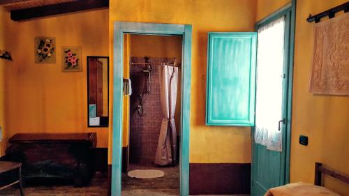 a bathroom with a shower and a glass door at Sa Corti De Sa Perda Piscinas in Piscinas