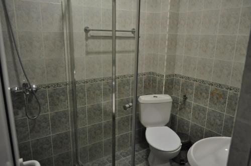 a bathroom with a shower with a toilet and a sink at Guest Rooms Biju in Tryavna