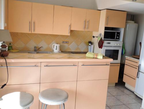 une cuisine avec des armoires blanches, un évier et une cuisinière dans l'établissement Residence de la Mer, à Antibes