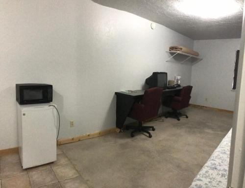 una oficina con ordenador, 2 sillas y escritorio en Arrowhead Point Lodge & Campground en Shay