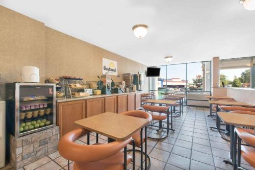 a restaurant with tables and chairs and a counter at Days Inn by Wyndham West Rapid City in Rapid City