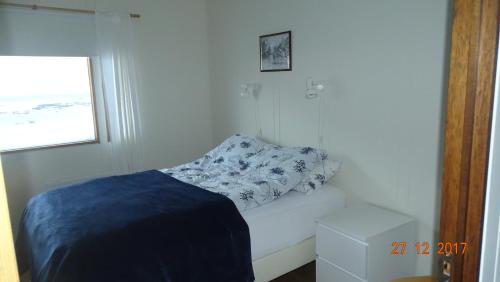a white room with a bed and a pillow at Miðjanes Reykhólahrepp in Reykhólar