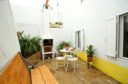 a room with a table and chairs and a fireplace at Casinha da Aldeia in Melides