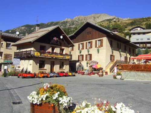 a large building with cars parked in a parking lot at La Vieille Auberge in Vars