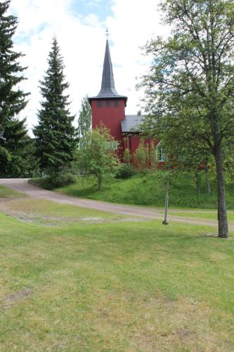 a red building with a steeple in the middle of a park at Trunna Vandrarhem & Konferens in Orsa