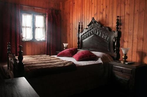 sypialnia z łóżkiem z czerwonymi poduszkami i oknem w obiekcie Casa de Marlães w mieście Lousada