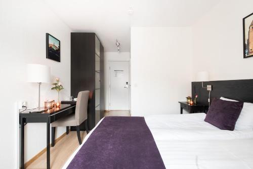 a hotel room with a bed and a desk and a desk at Best Western Hotel City Gavle in Gävle