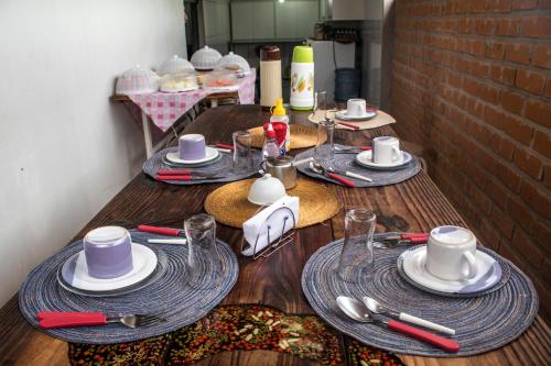 Pousada Piçarras في لينكويس: طاولة خشبية عليها صحون واكواب