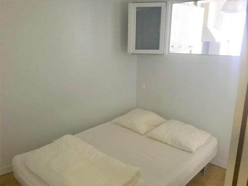 un lit blanc dans une chambre avec une fenêtre dans l'établissement Appt 2 à 4 pers - La Rochelle Vieux Port, à La Rochelle