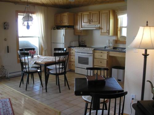 a kitchen with a table and chairs and a dining room at Haus Treuburg in Port Hood